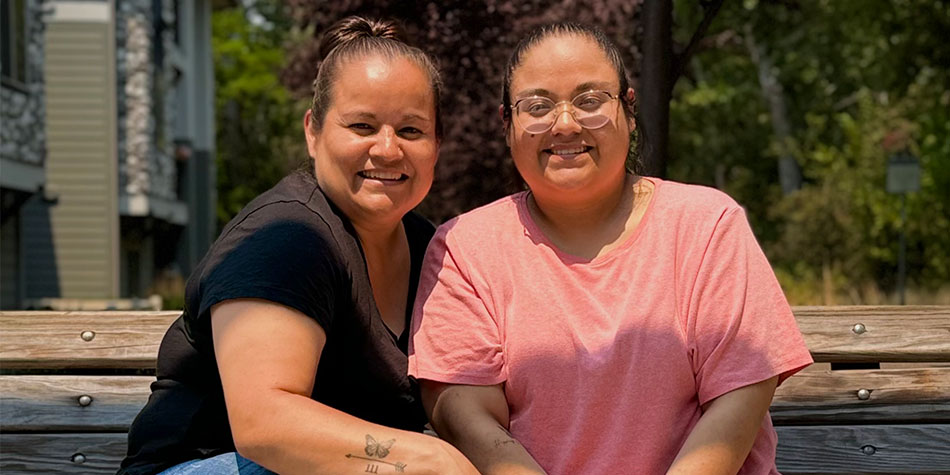 Mother and daughter sitting on a bench.